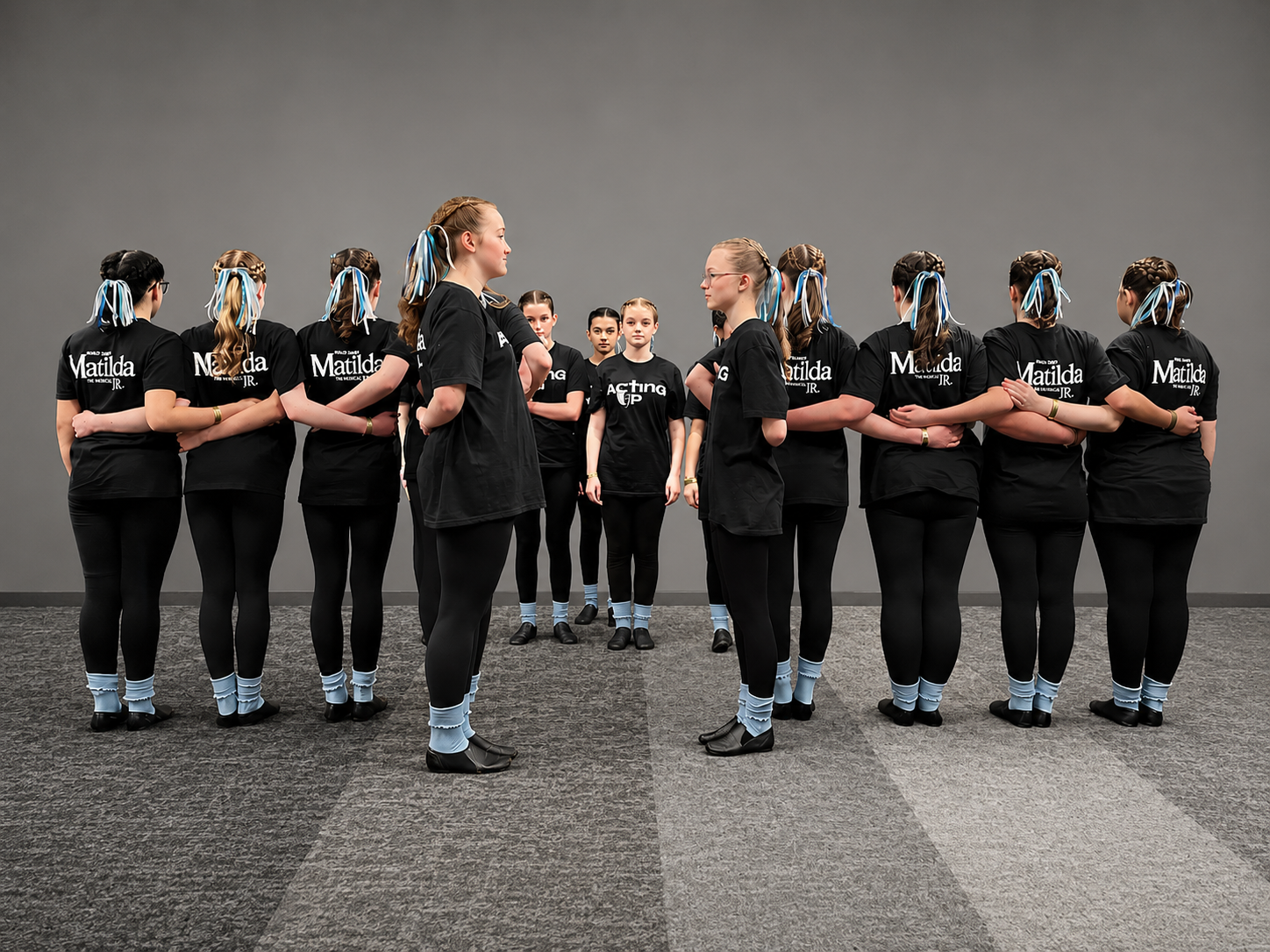 A youth theatre troupe standing together, arms linked